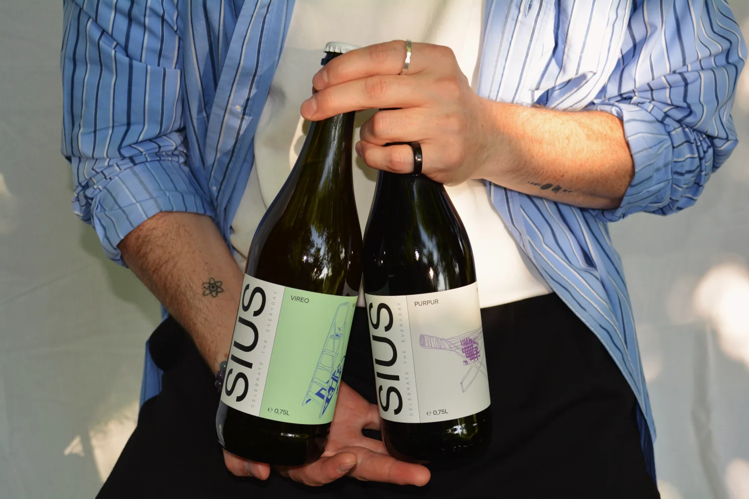 Der Gründer von SIUS Brewing hält zwei Glasflaschen mit alkoholfreien Proxies in der Hand.